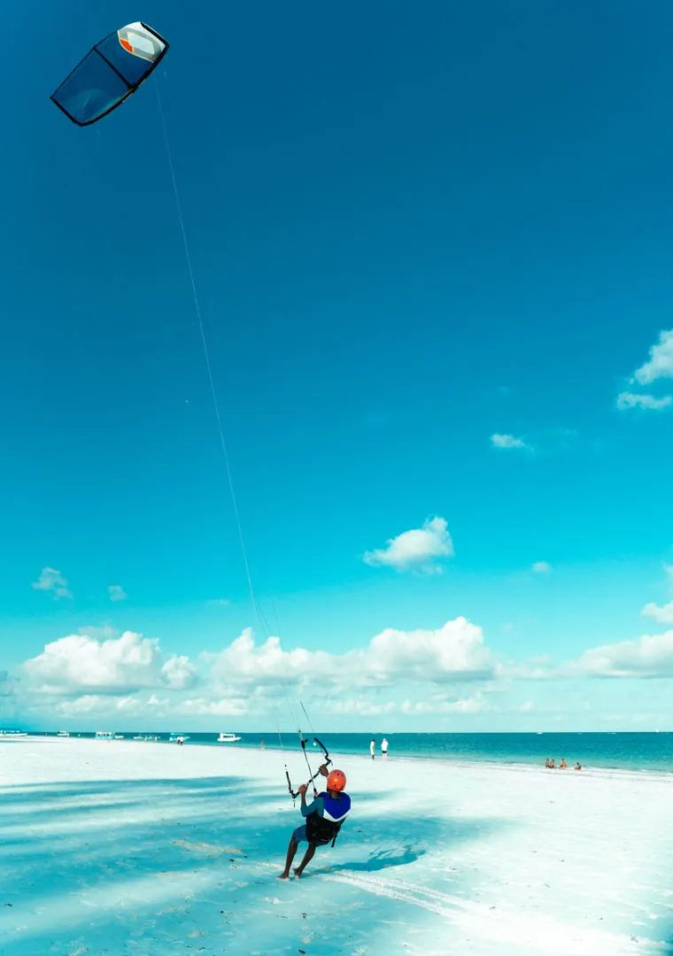 Kitesurfer on a bright coastal beach